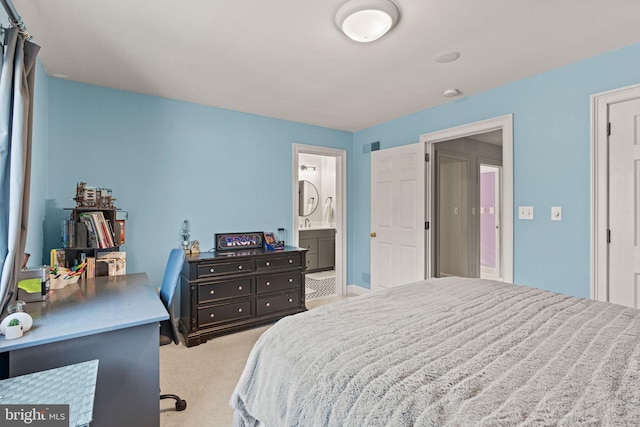 bedroom featuring ensuite bath and light colored carpet