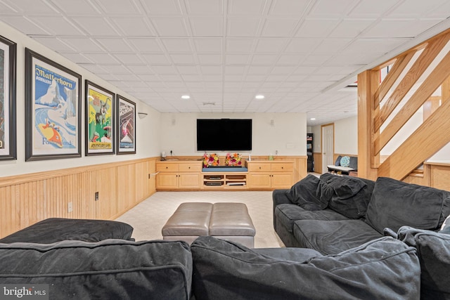 living room with light colored carpet and wood walls