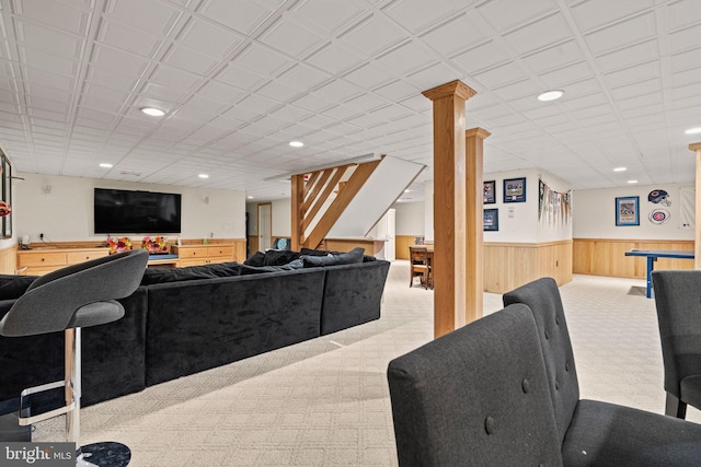 living room featuring light colored carpet and wooden walls