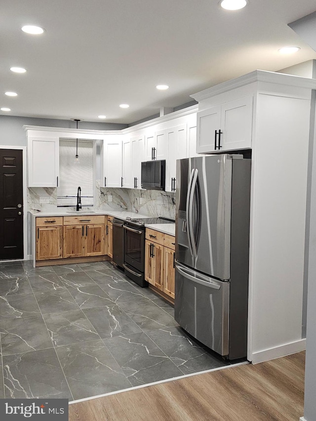 kitchen featuring white cabinets, decorative backsplash, sink, and black appliances