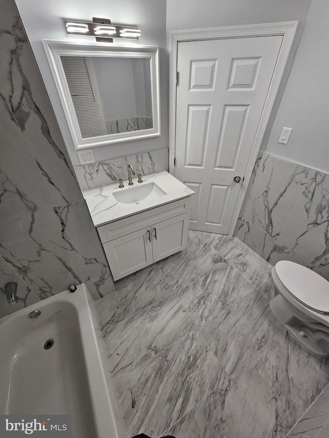 bathroom featuring vanity, toilet, and tile walls