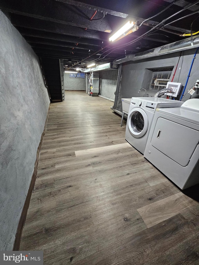 washroom featuring hardwood / wood-style flooring and washing machine and clothes dryer