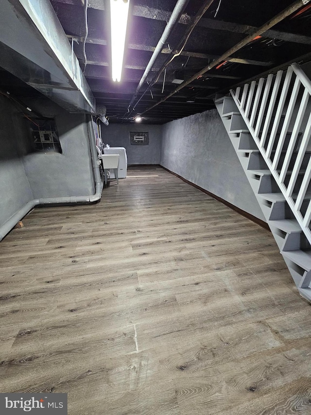 basement featuring hardwood / wood-style floors and sink