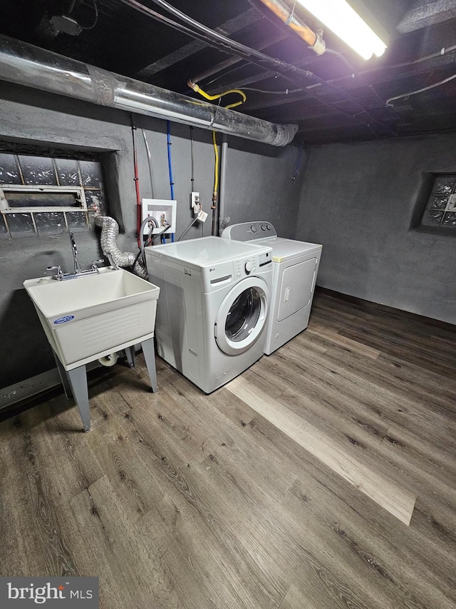 laundry area featuring sink, washer and dryer, and hardwood / wood-style flooring