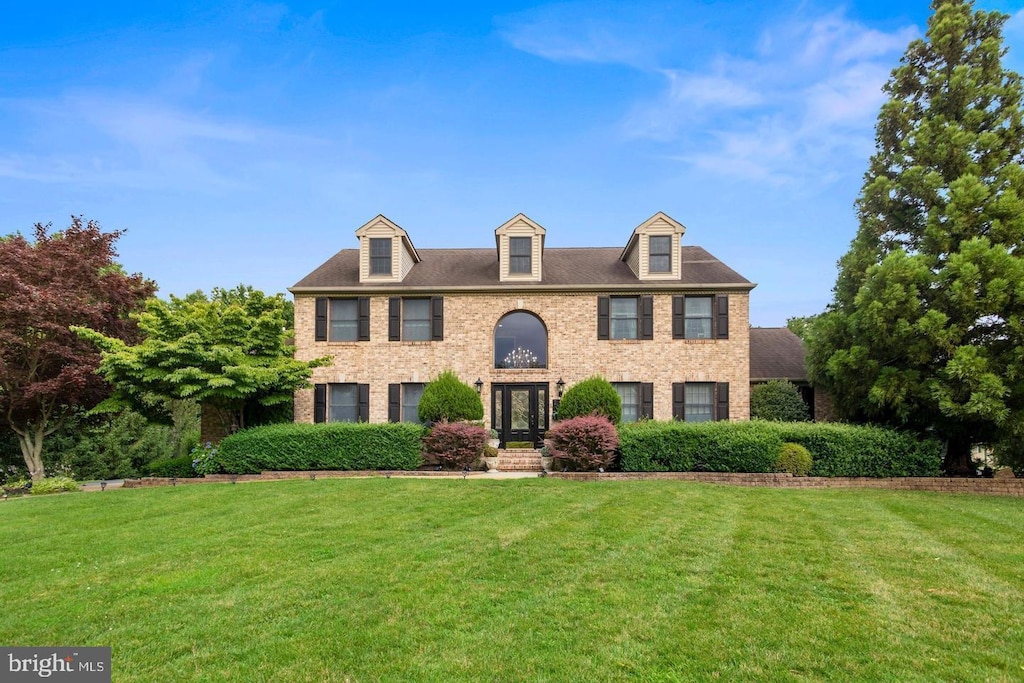 colonial home featuring french doors and a front yard