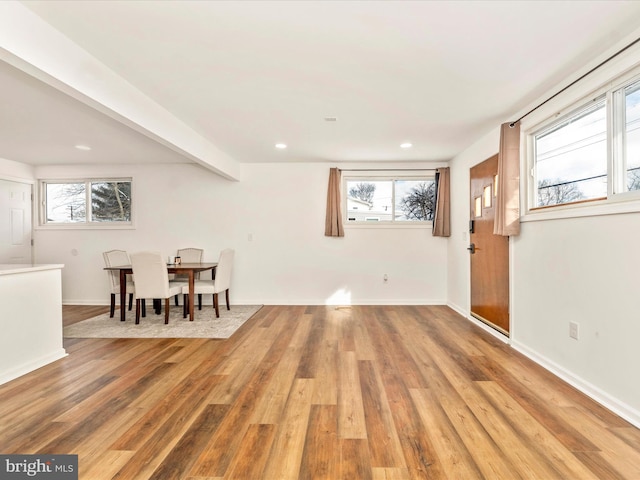 foyer entrance with wood-type flooring and beam ceiling