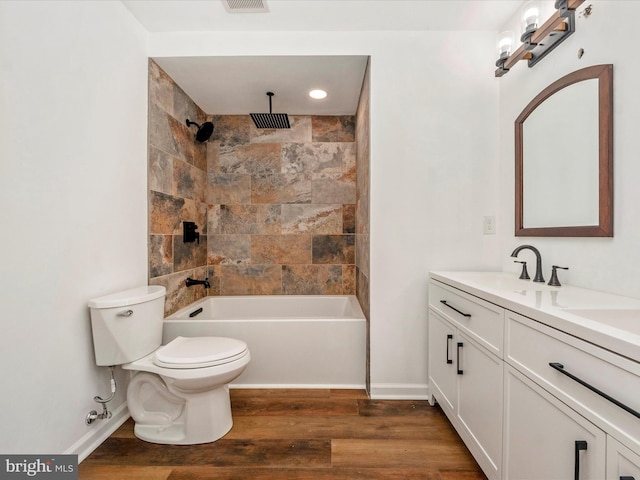 full bathroom featuring toilet, vanity, tiled shower / bath combo, and hardwood / wood-style flooring