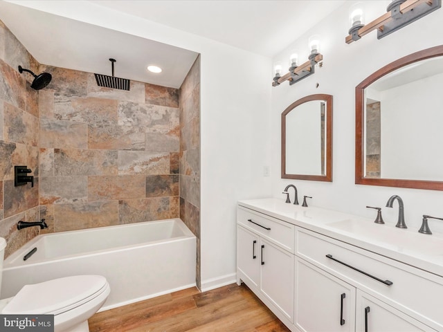 full bathroom featuring vanity, hardwood / wood-style flooring, toilet, and tiled shower / bath