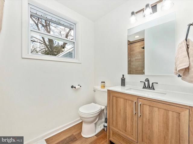 bathroom featuring walk in shower, vanity, wood-type flooring, and toilet