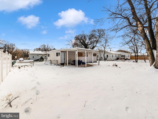 view of snow covered back of property