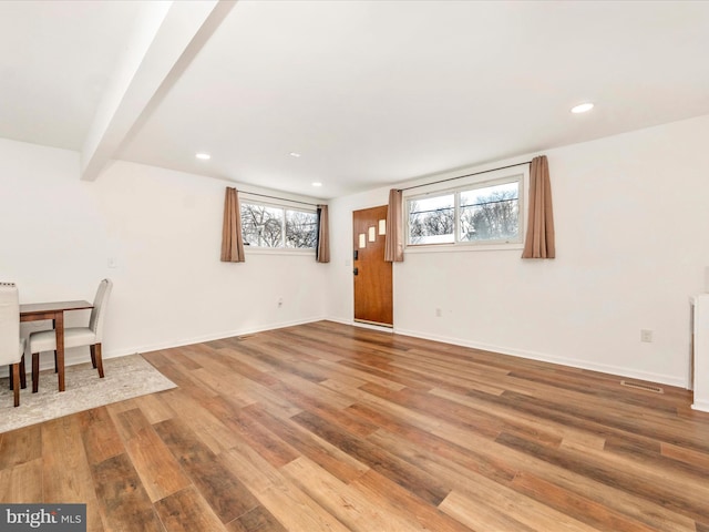 interior space featuring beamed ceiling, wood-type flooring, and a wealth of natural light