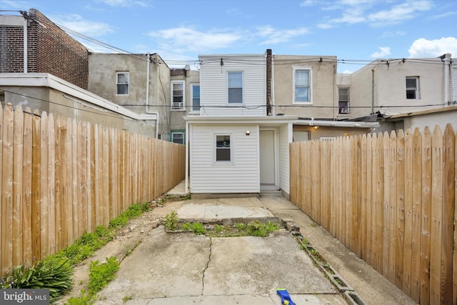rear view of property featuring stucco siding, a fenced backyard, and a patio area
