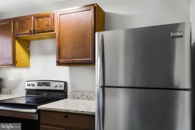 kitchen featuring appliances with stainless steel finishes, decorative backsplash, and light stone counters