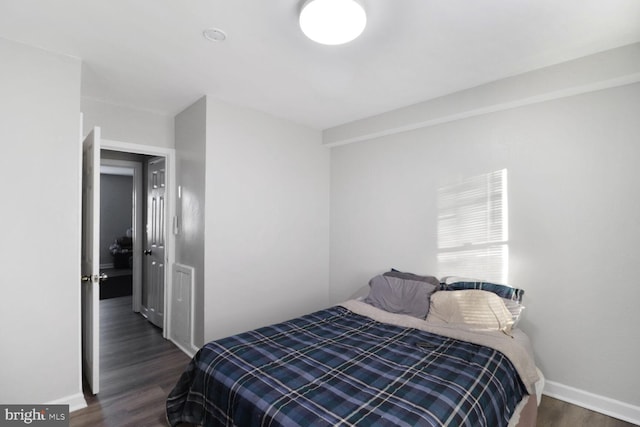 bedroom with dark hardwood / wood-style floors