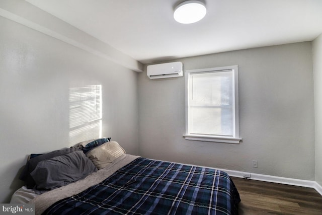 bedroom featuring a wall mounted air conditioner and dark hardwood / wood-style flooring