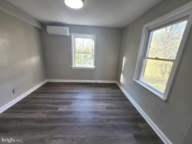 unfurnished room with dark hardwood / wood-style floors and a wall unit AC