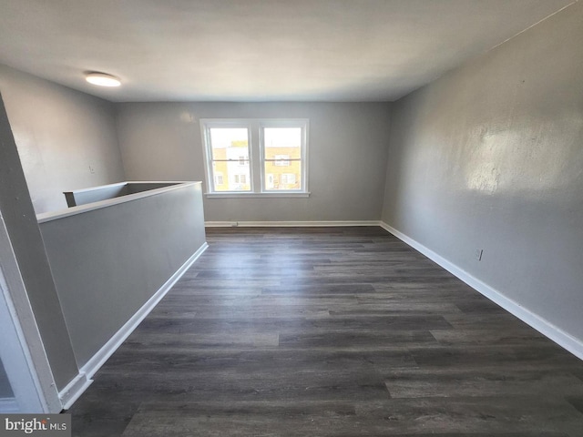 empty room with dark hardwood / wood-style flooring