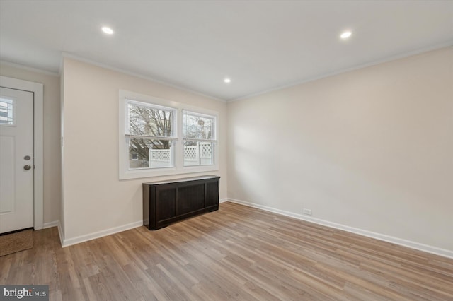 entrance foyer with crown molding and light hardwood / wood-style flooring