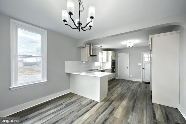 kitchen featuring kitchen peninsula, plenty of natural light, hanging light fixtures, and an inviting chandelier