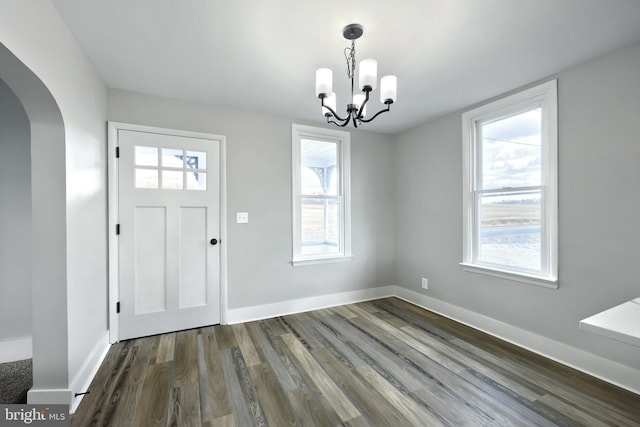 foyer entrance featuring dark wood-type flooring and a notable chandelier