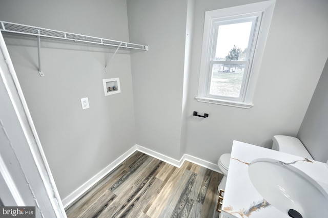 clothes washing area with hookup for a washing machine, sink, and hardwood / wood-style floors