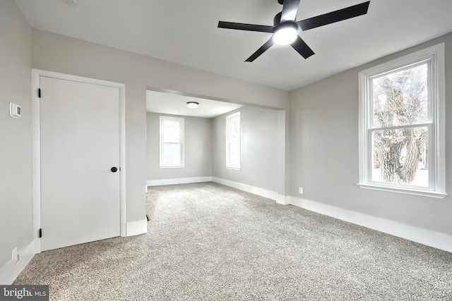 carpeted empty room featuring ceiling fan