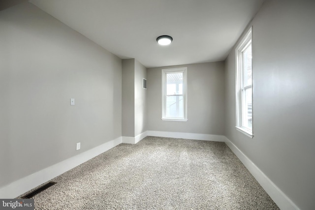 spare room featuring carpet flooring and a healthy amount of sunlight