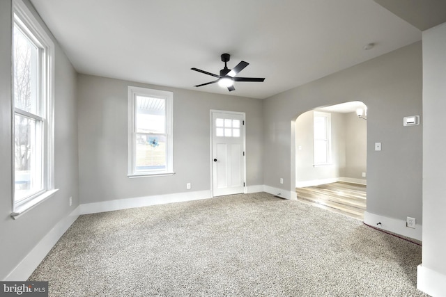 spare room featuring ceiling fan, carpet floors, and a wealth of natural light