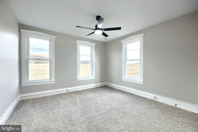 empty room with carpet floors, plenty of natural light, and ceiling fan