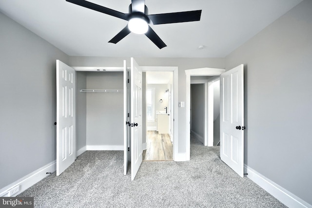 unfurnished bedroom featuring ceiling fan, light carpet, and a closet