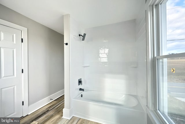 bathroom with shower / tub combination, a healthy amount of sunlight, and hardwood / wood-style flooring