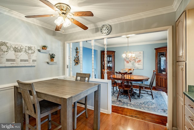 dining room featuring crown molding, light hardwood / wood-style floors, and ceiling fan with notable chandelier