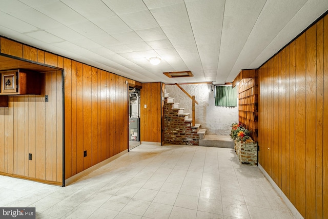 basement featuring wooden walls