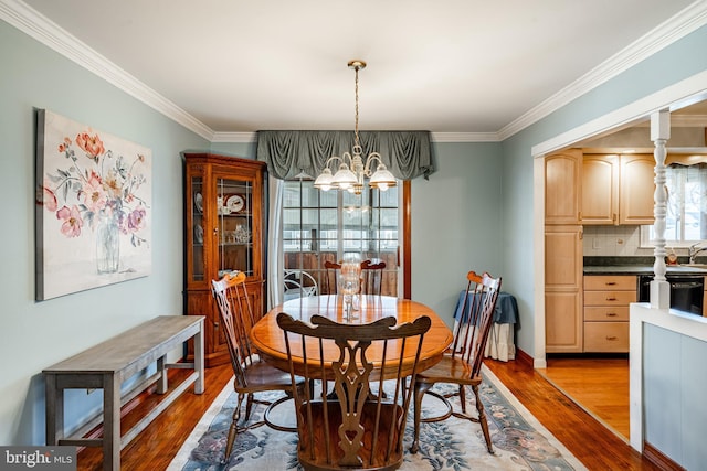 dining room featuring hardwood / wood-style flooring, ornamental molding, and a chandelier