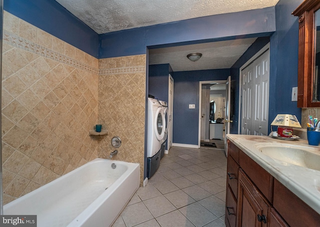 bathroom with tile patterned flooring, vanity, separate washer and dryer, and a textured ceiling