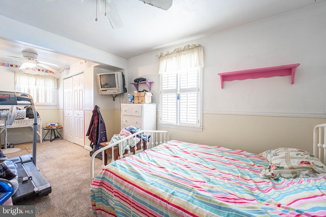 carpeted bedroom with ceiling fan and a closet