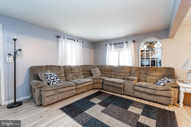 living room with a textured ceiling and light hardwood / wood-style floors