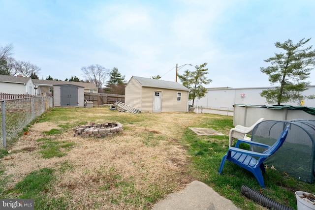 view of yard featuring a fire pit and a storage shed