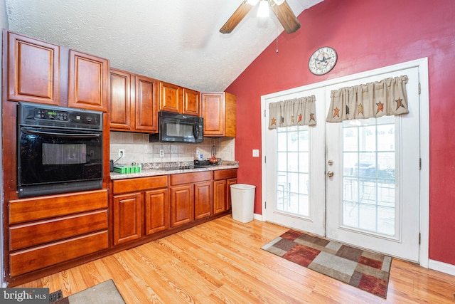 kitchen with backsplash, french doors, black appliances, vaulted ceiling, and light wood-type flooring