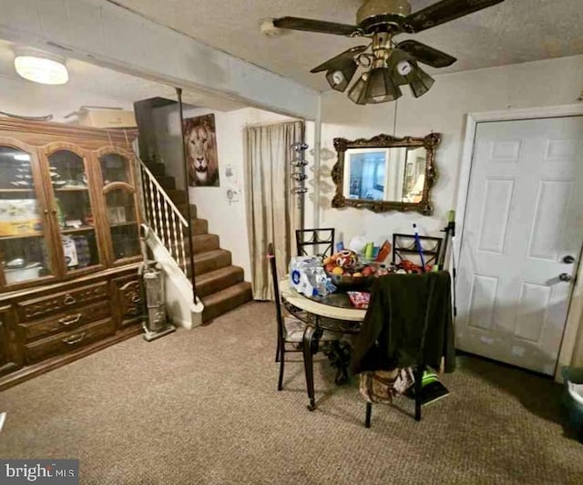 dining area featuring ceiling fan, carpet floors, and a textured ceiling