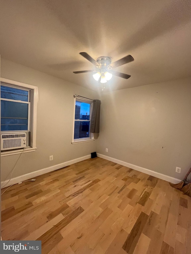 unfurnished room with ceiling fan, light hardwood / wood-style flooring, and cooling unit