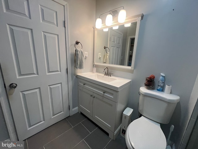 bathroom with tile patterned flooring, vanity, and toilet