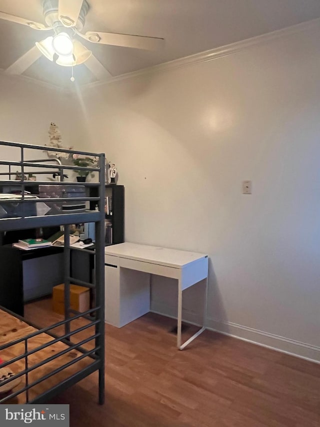 bedroom with dark hardwood / wood-style flooring, ceiling fan, and crown molding