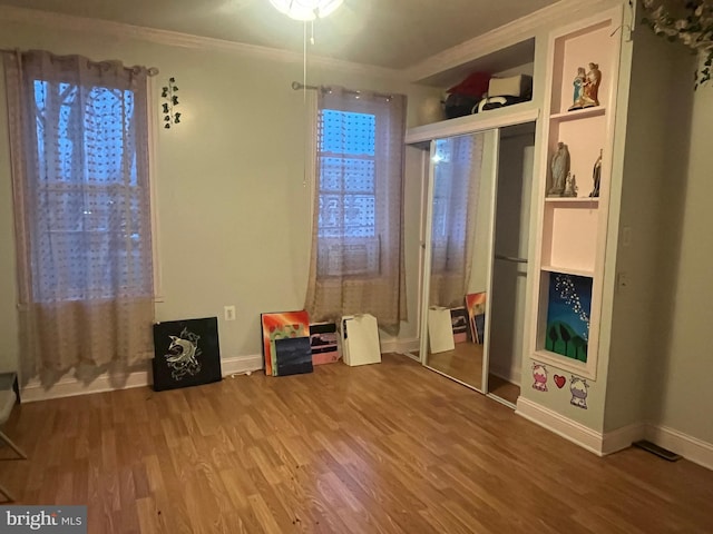 interior space featuring hardwood / wood-style floors and ornamental molding