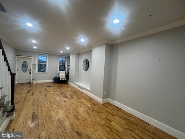 interior space with light wood-type flooring and crown molding