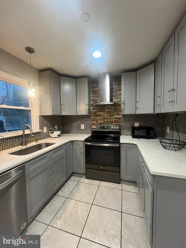 kitchen featuring gray cabinets, sink, wall chimney range hood, and appliances with stainless steel finishes