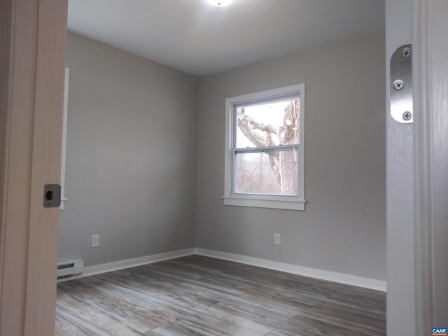 spare room with wood-type flooring and a baseboard radiator