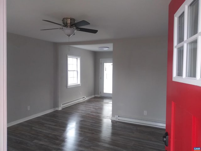 unfurnished room featuring baseboard heating, ceiling fan, and dark wood-type flooring