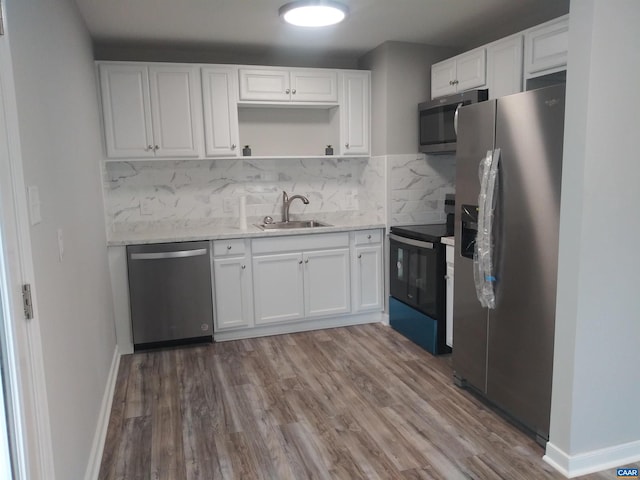 kitchen with white cabinets, appliances with stainless steel finishes, tasteful backsplash, and sink