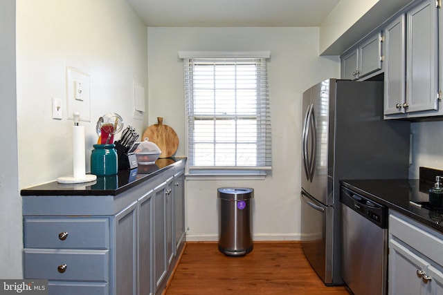 kitchen featuring dishwasher, gray cabinets, dark wood-type flooring, and a wealth of natural light